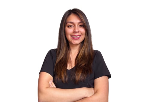 Woman with long brown hair wearing a black v-neck t-shirt, smiling with arms crossed against white background