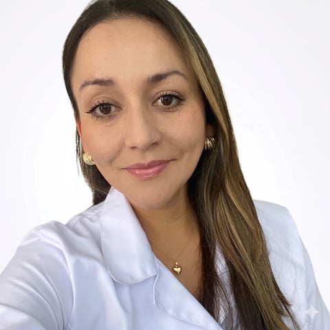 Professional headshot of a woman with long brown hair wearing a white collared shirt and gold hoop earrings against a white background